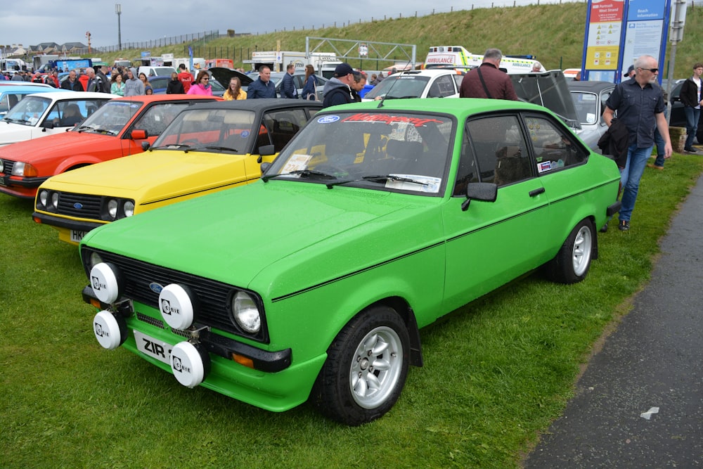 green and yellow car on green grass field during daytime