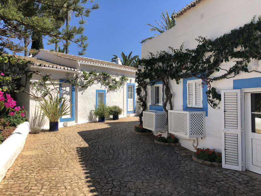 A whitewashed Portuguese villa with blue details in summer sun