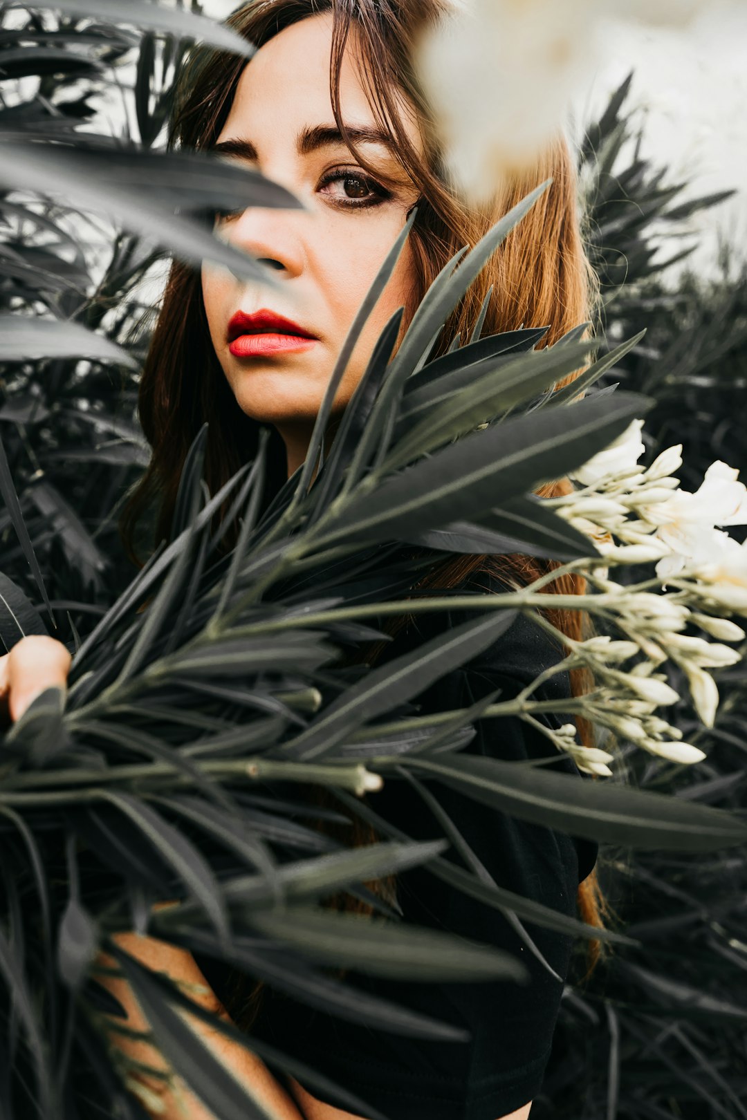 woman in black shirt standing beside white flowers