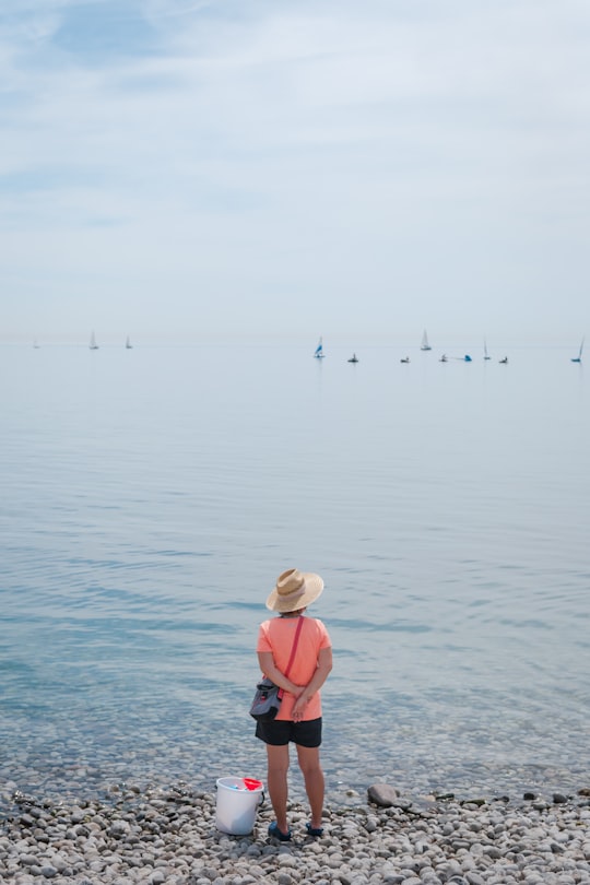 woman in pink shirt and black pants standing on water during daytime in Oakville Canada