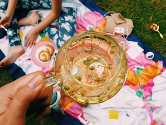 person holding clear glass mug