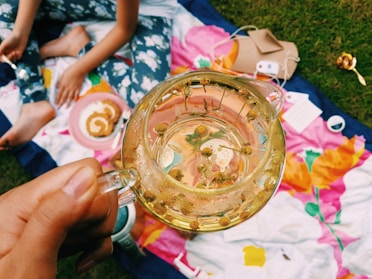 person holding clear glass mug