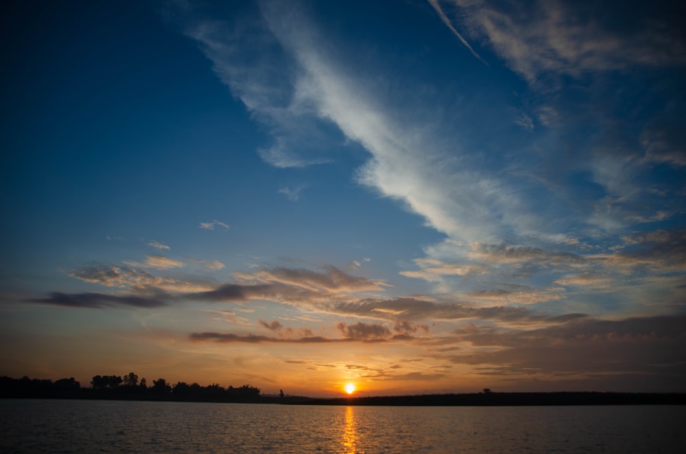 body of water under blue sky during sunset