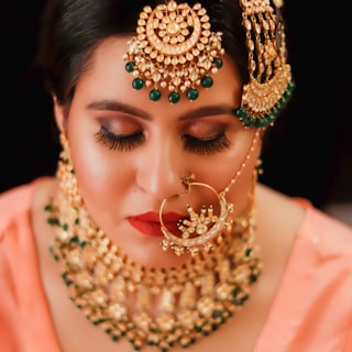 woman in pink dress wearing gold and red beaded necklace