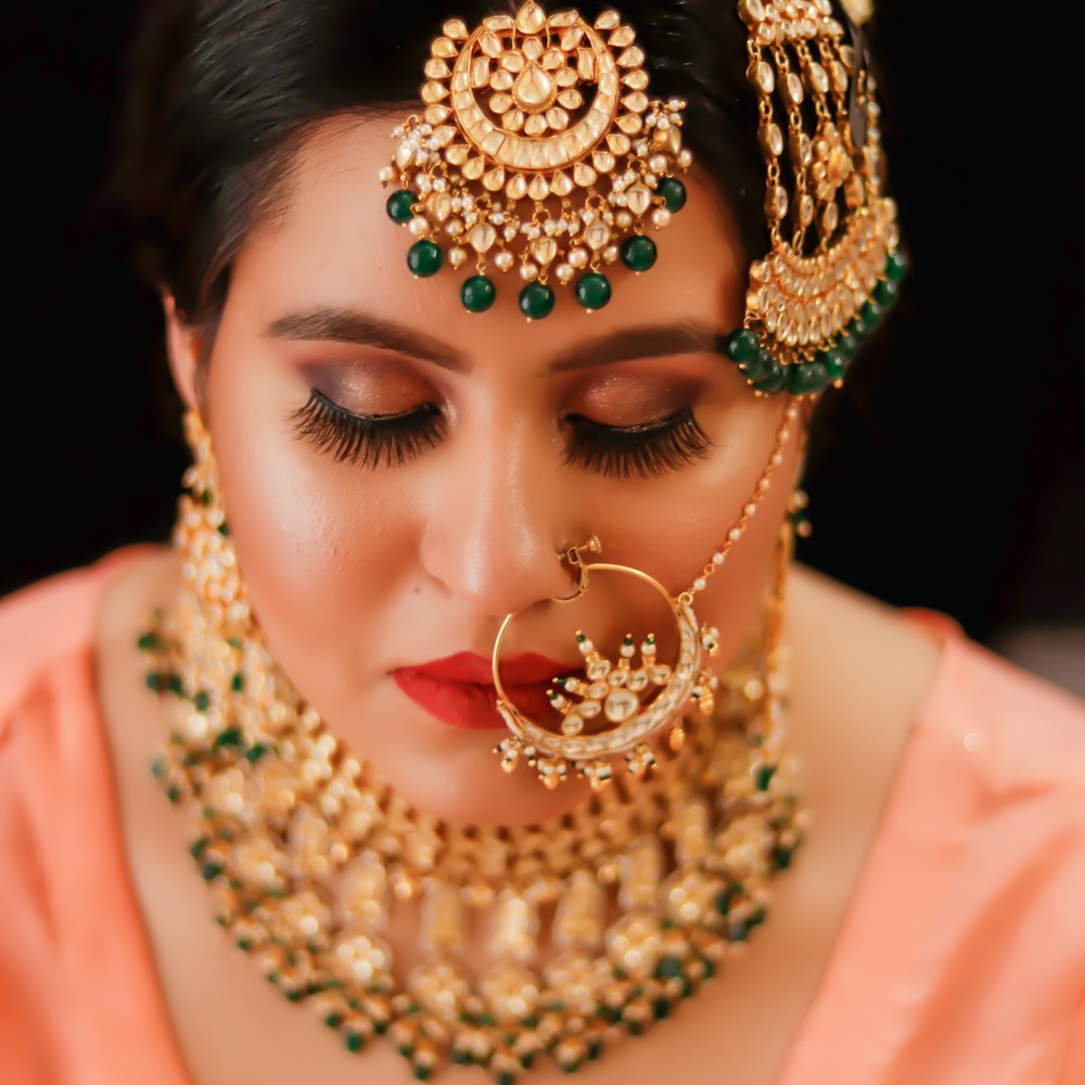 Femme en robe rose portant un collier de perles or et rouge