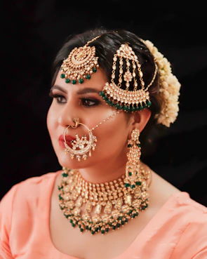 A model wearing a royal black and antique gold necklace set paired with matching earrings at a festive event.
