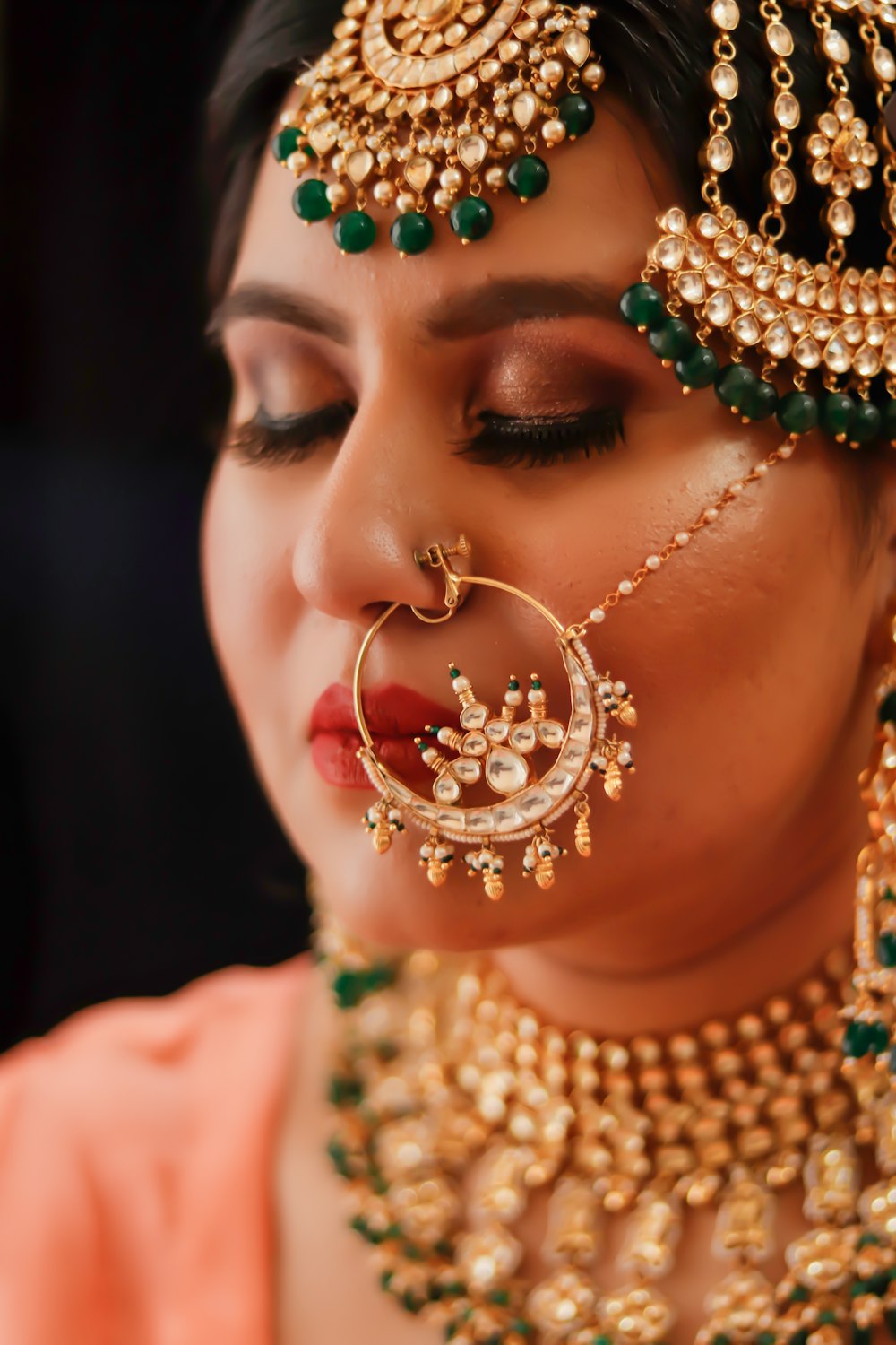 Femme avec des boucles d’oreilles vertes et dorées