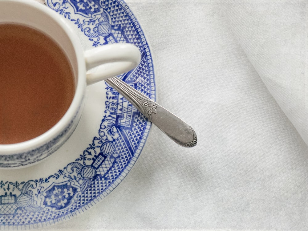 weiße und blaue florale Keramik-Teetasse mit Untertasse