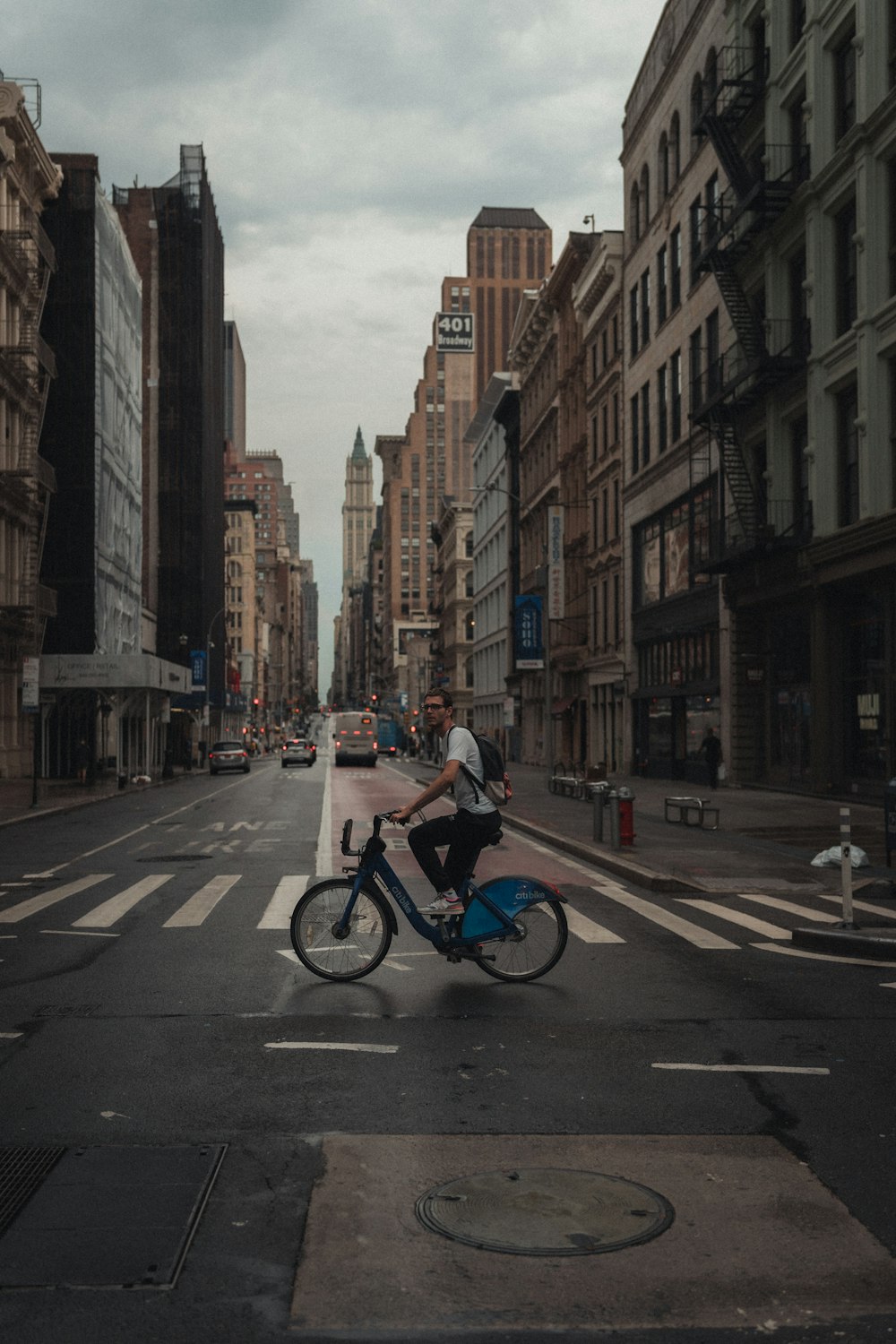 man in blue shirt riding bicycle on road during daytime