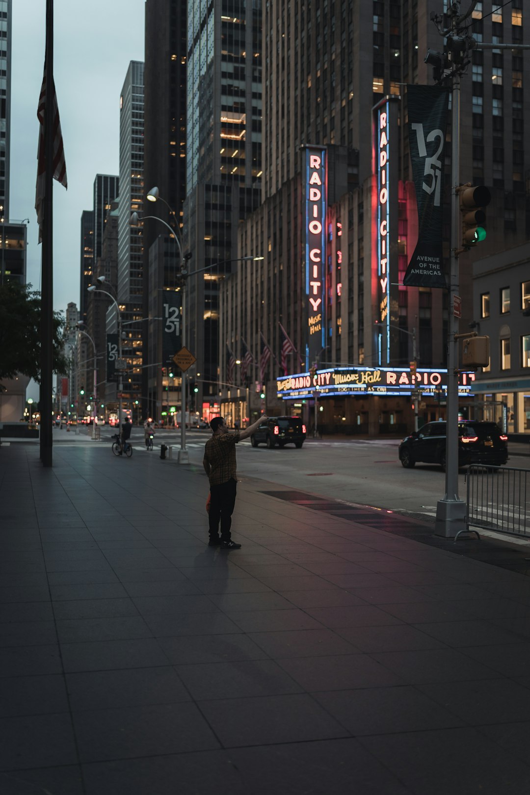people walking on sidewalk near city buildings during night time