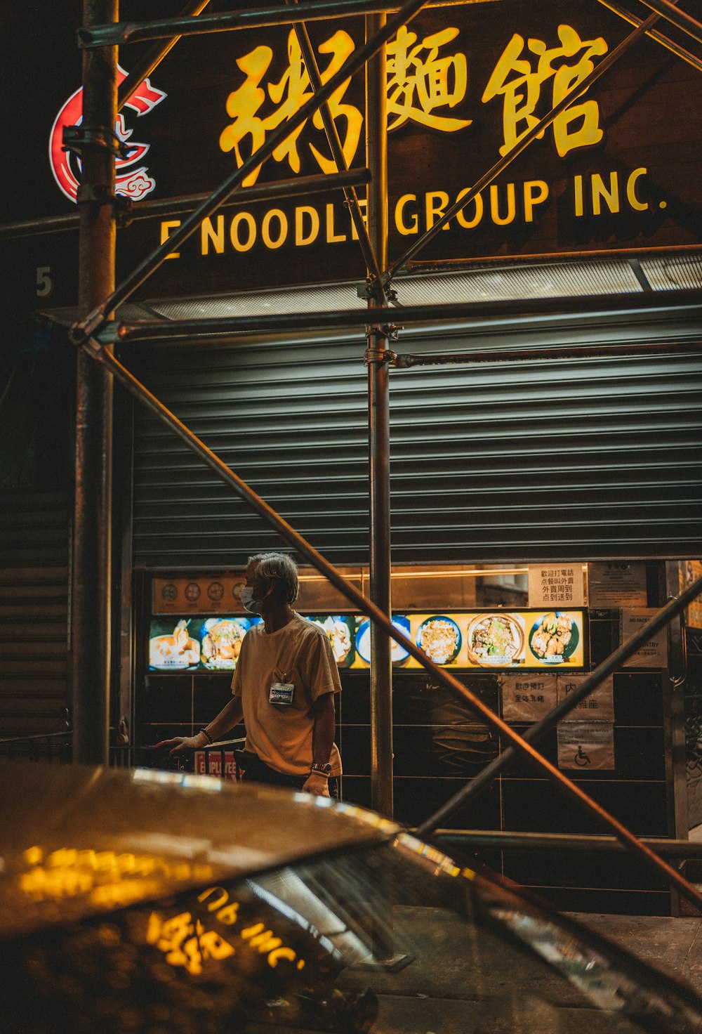 man in blue jacket standing in front of brown wooden store