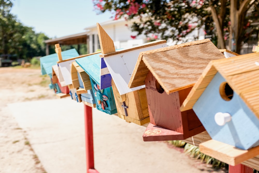 Casita para pájaros de madera marrón sobre arena marrón durante el día