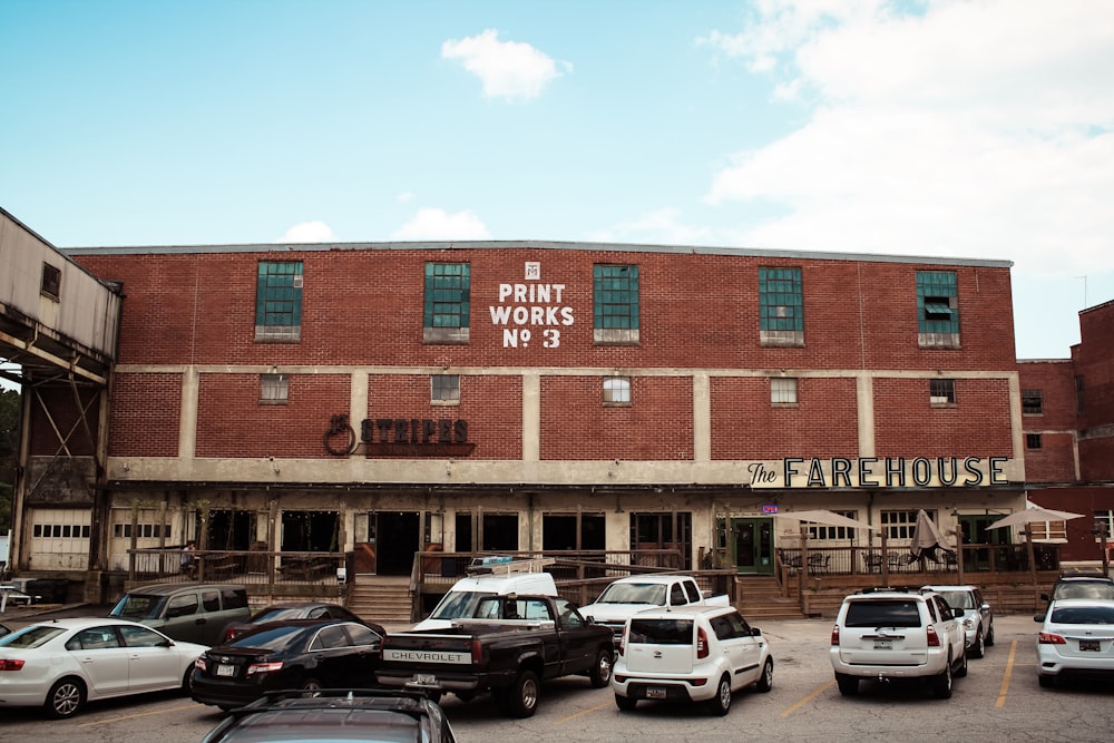 cars parked in front of brown building during daytime