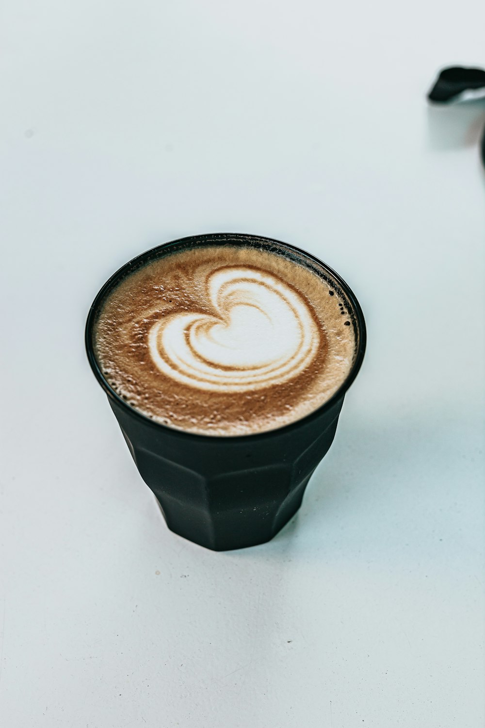 black and white ceramic cup with heart shaped coffee