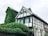 white and green concrete house near green trees during daytime