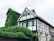 white and green concrete house near green trees during daytime