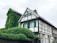 white and green concrete house near green trees during daytime