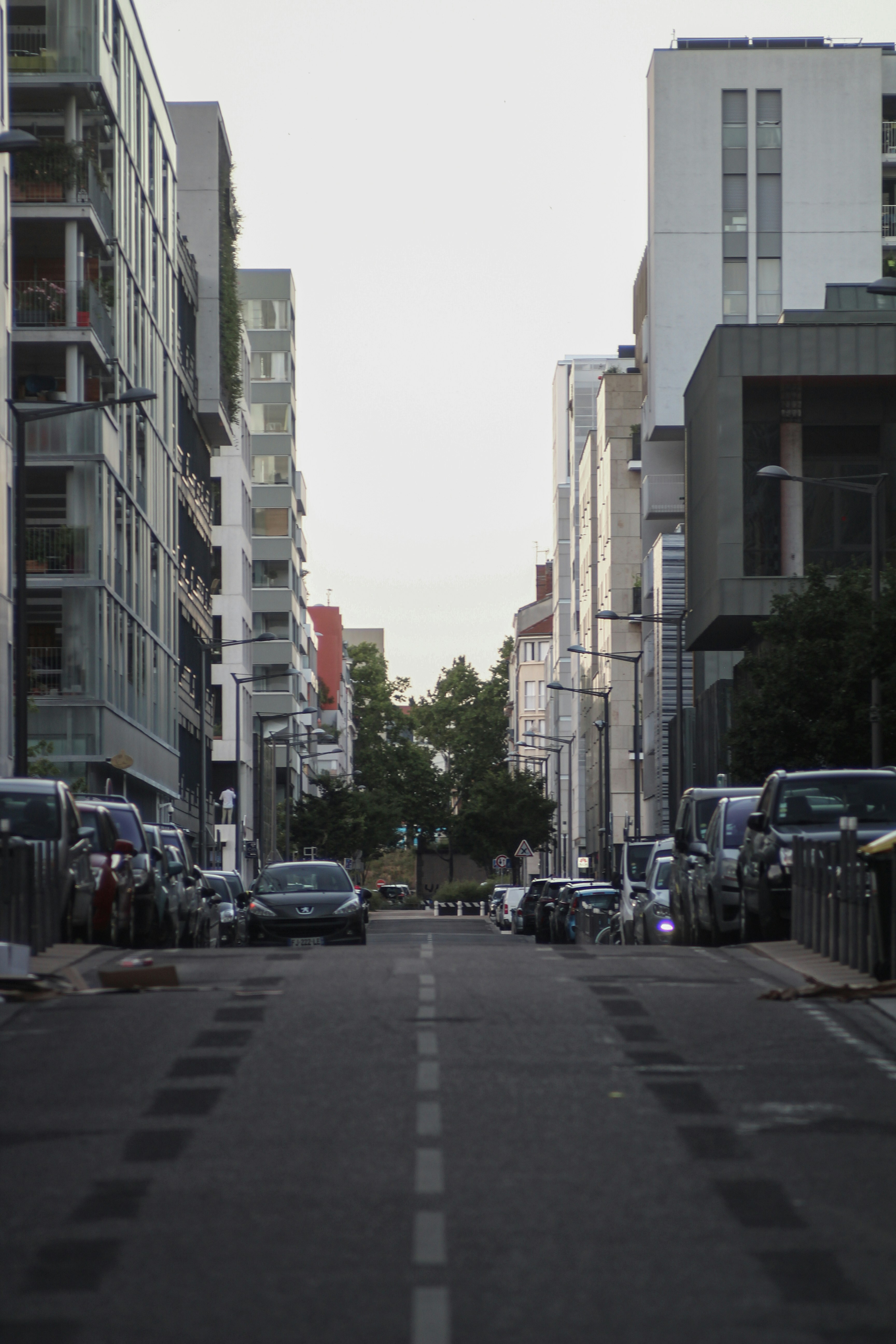 cars parked on side of the road near buildings during daytime