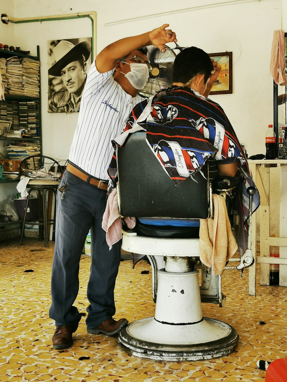 man in black and white stripe shirt sitting on barber chair