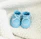 Close-up of adorable baby shoes on a soft white blanket with a blue accent