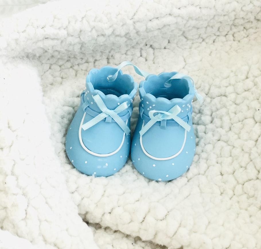 Hellblaue Babyschuhe auf einer weichen Decke – Erinnerungen ans erste Jahr