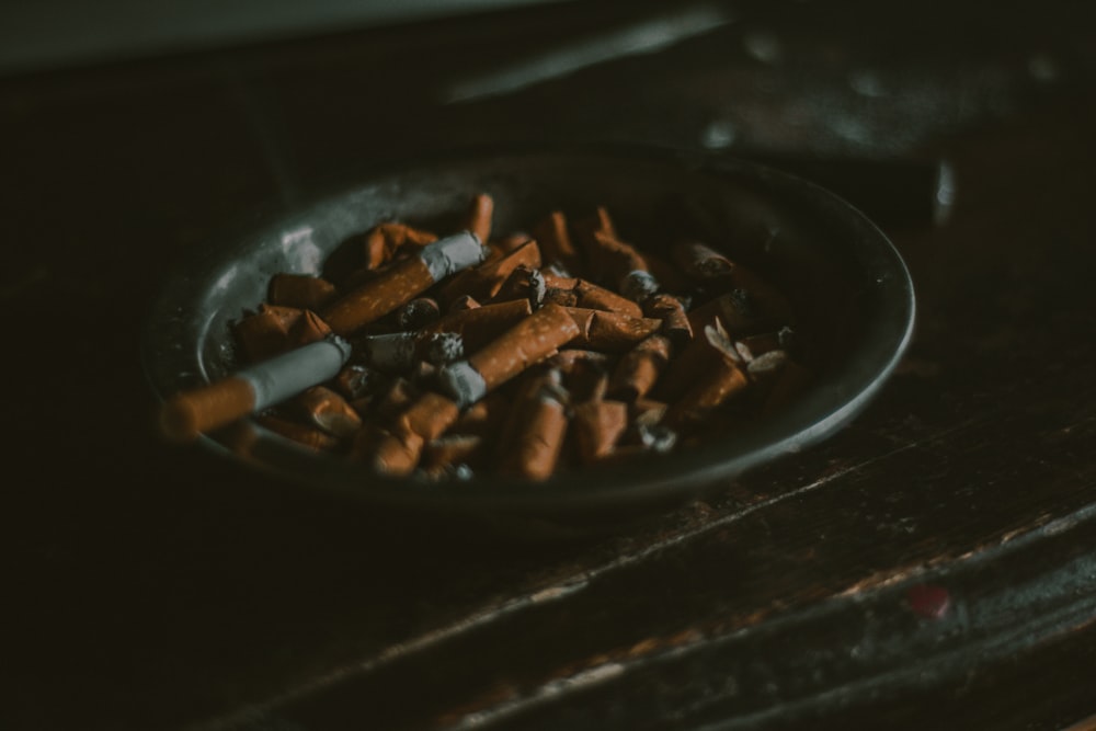 mégots de cigarettes sur cendrier rond noir