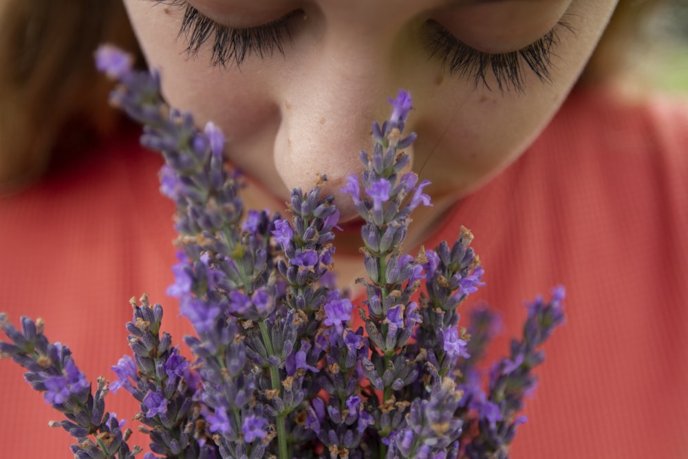 woman in orange shirt with purple flowers on her head