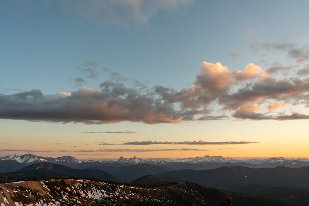 mountains under white clouds and blue sky during daytime