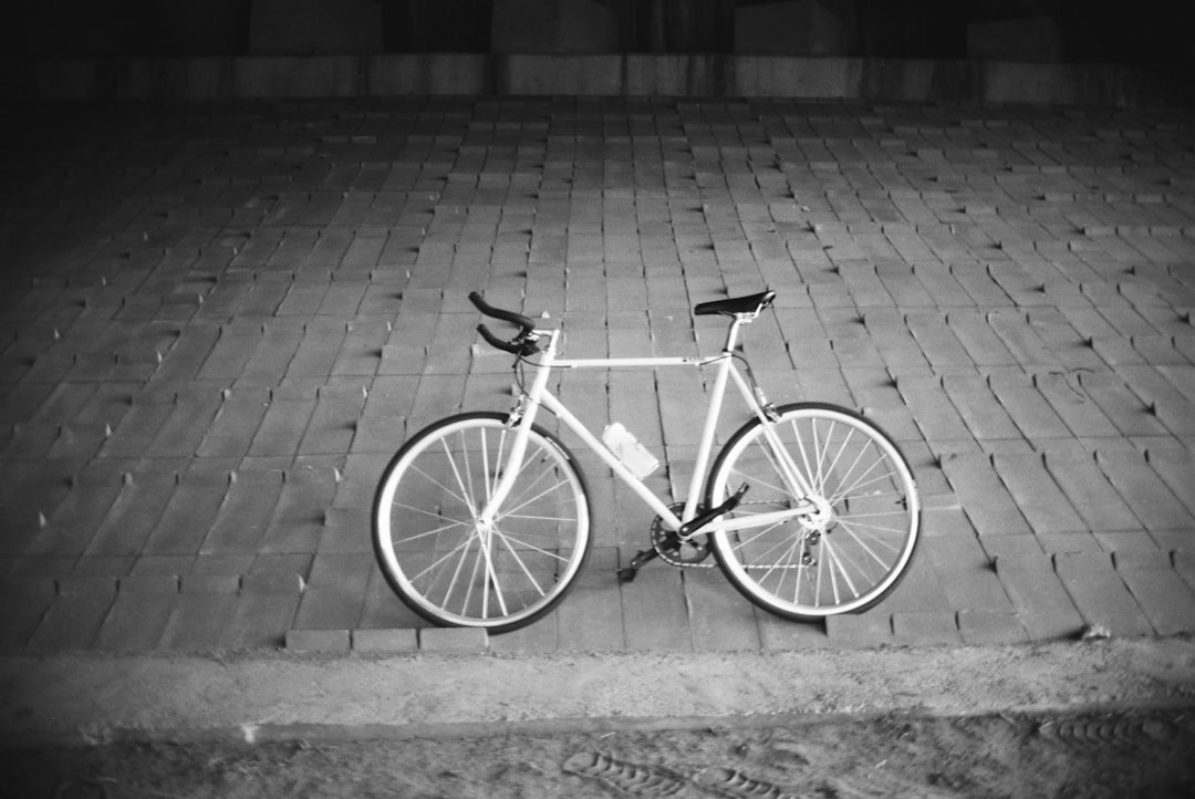grayscale photo of city bicycle on brick floor