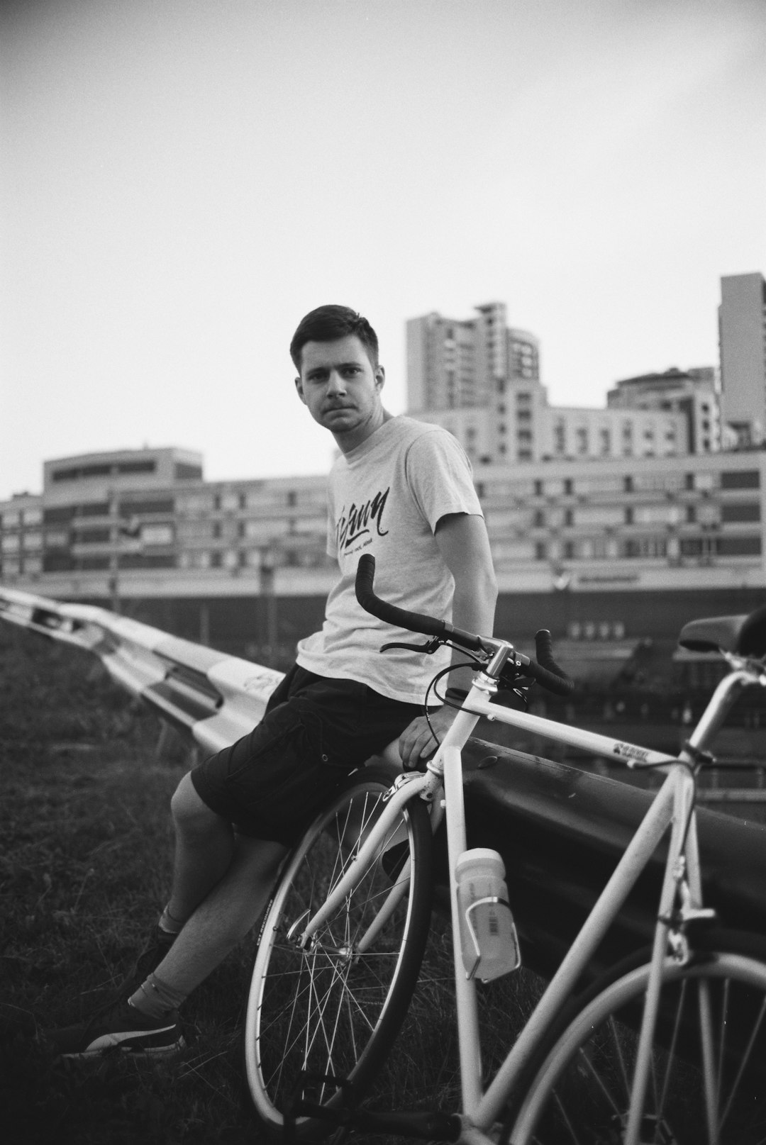 man in white crew neck t-shirt sitting on bicycle