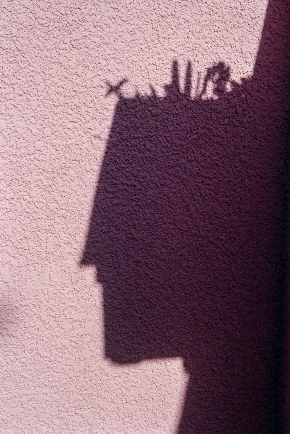 shadow of person on red concrete wall