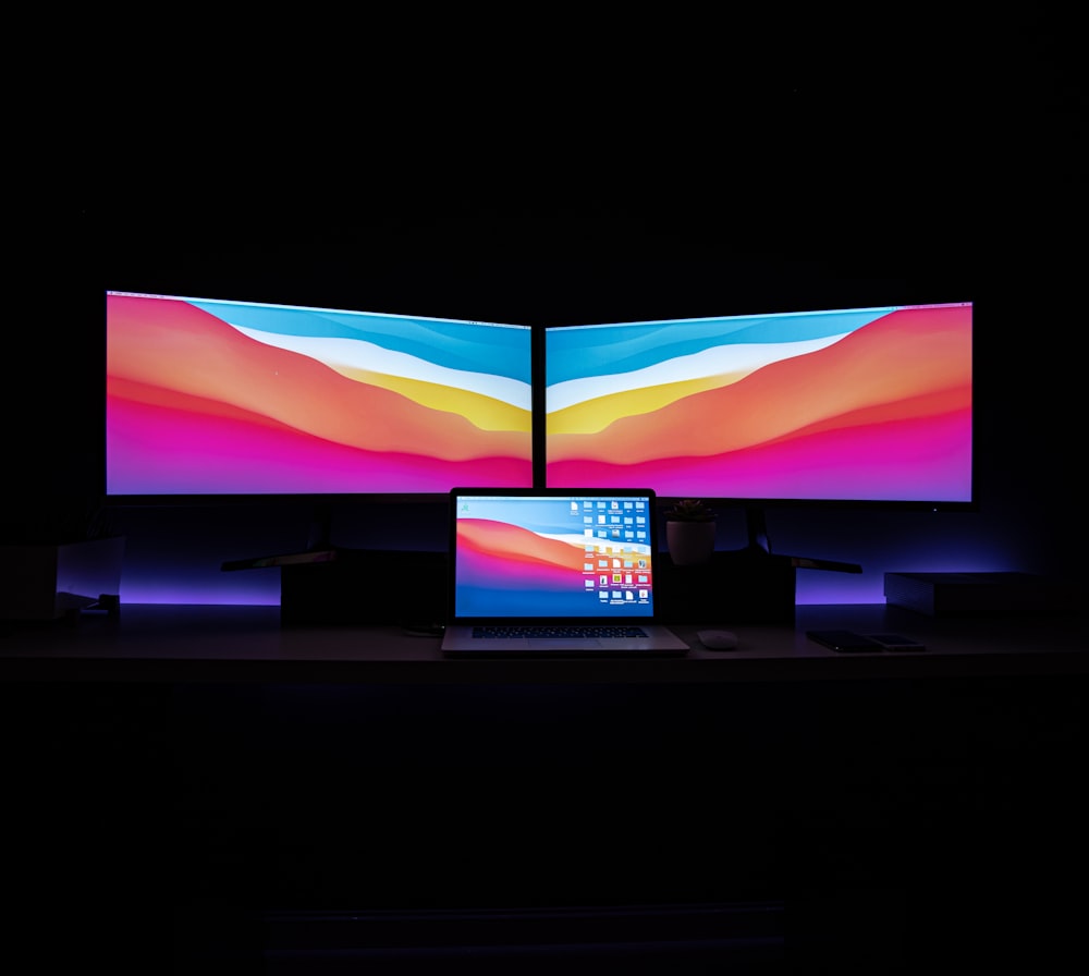 Televisor de pantalla plana negro encendido con azul y rosa