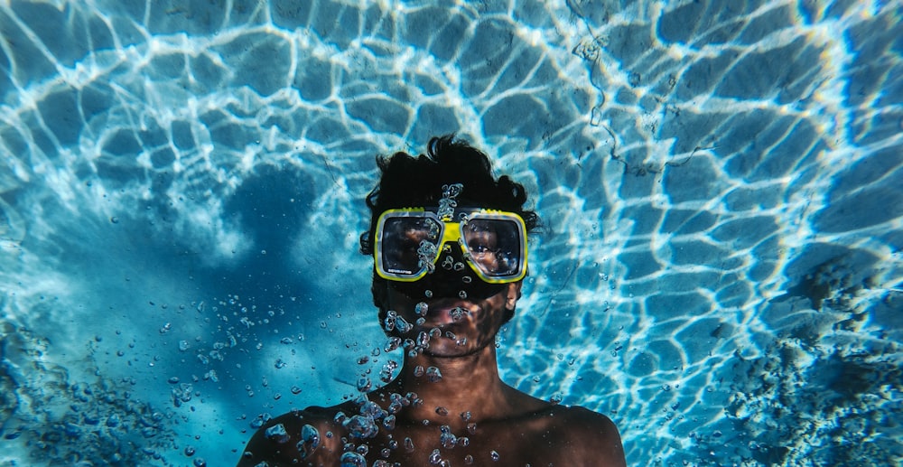 man in blue goggles under water