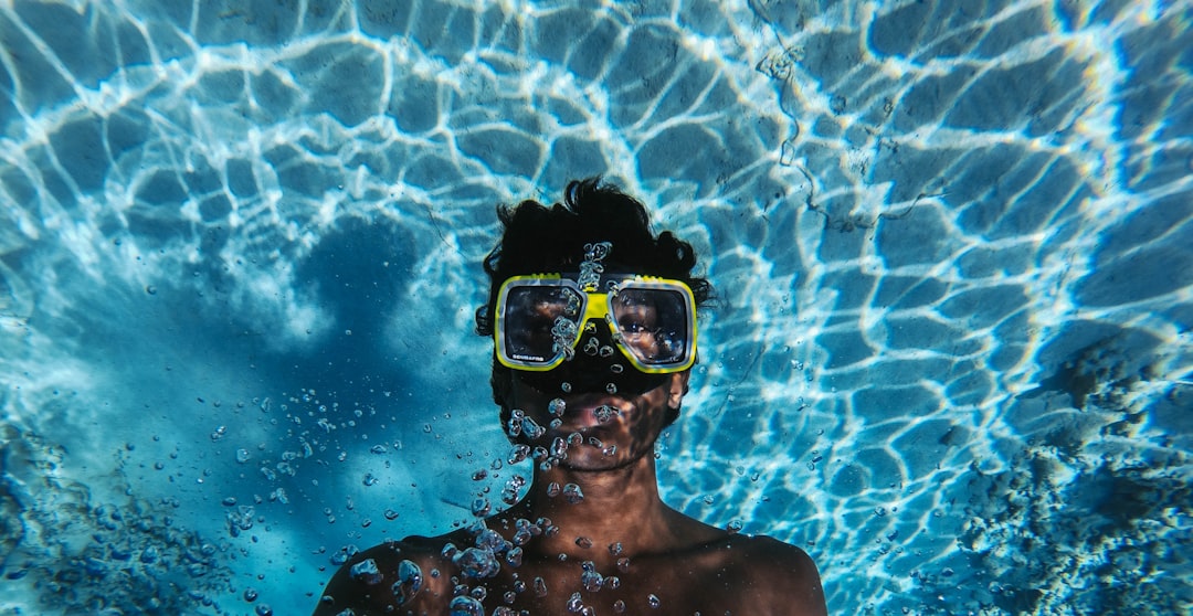 man in blue goggles under water
