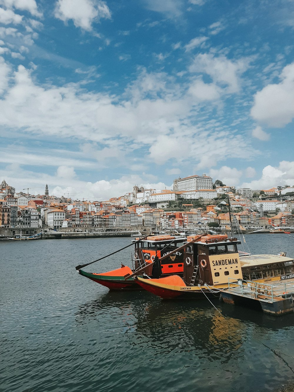 Bote rojo en el cuerpo de agua cerca de los edificios de la ciudad durante el día