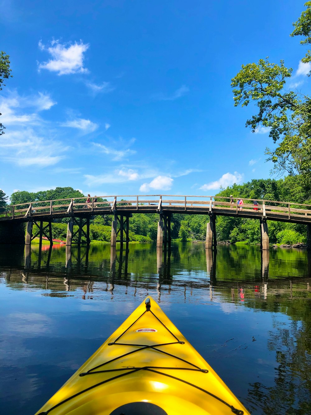 yellow kayak on river under blue sky during daytime