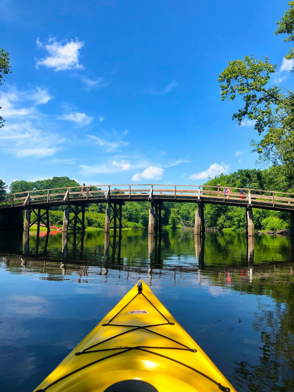 kayak giallo sul fiume sotto il cielo blu durante il giorno