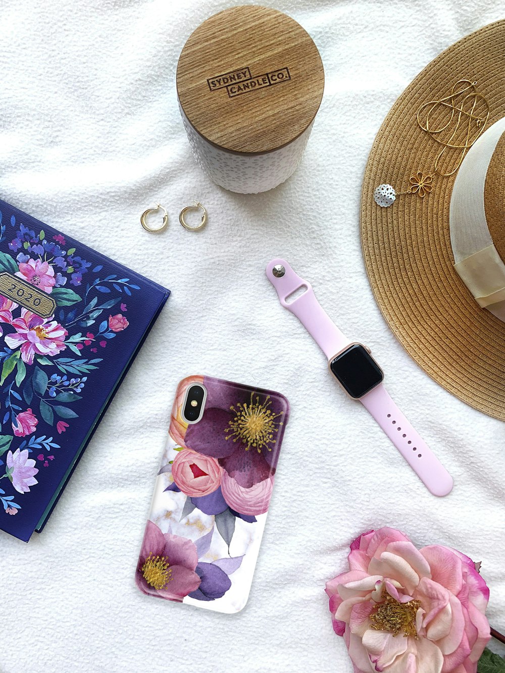 pink and black hair brush beside purple and white floral iphone case