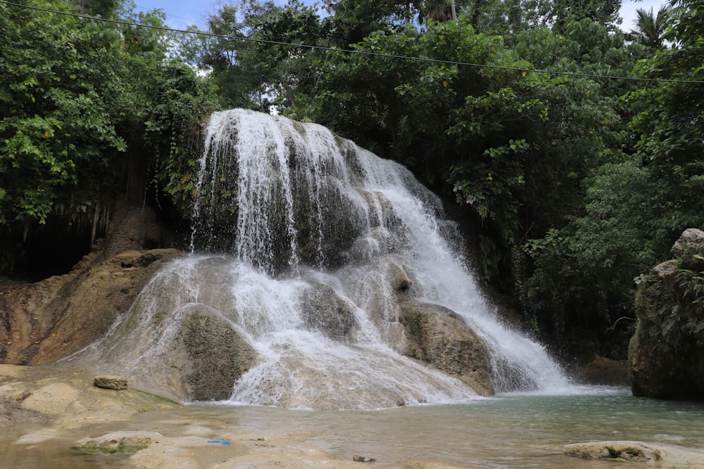 waterfalls in the middle of the forest during daytime