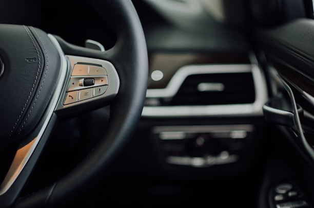 Close-up of a luxury car's steering wheel inside a sleek, modern vehicle.