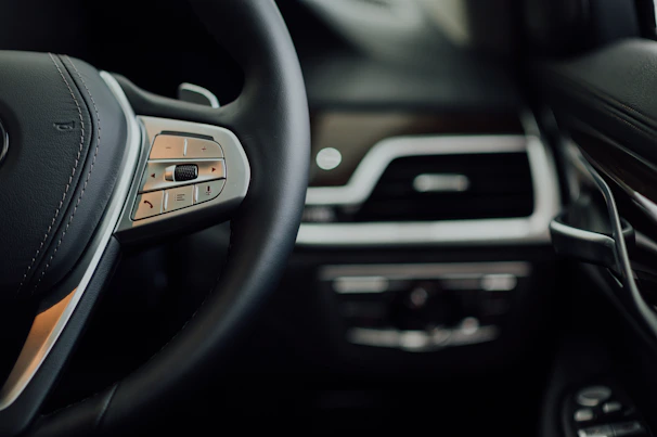 Close-up of a sleek car interior highlighting the dashboard and steering wheel.