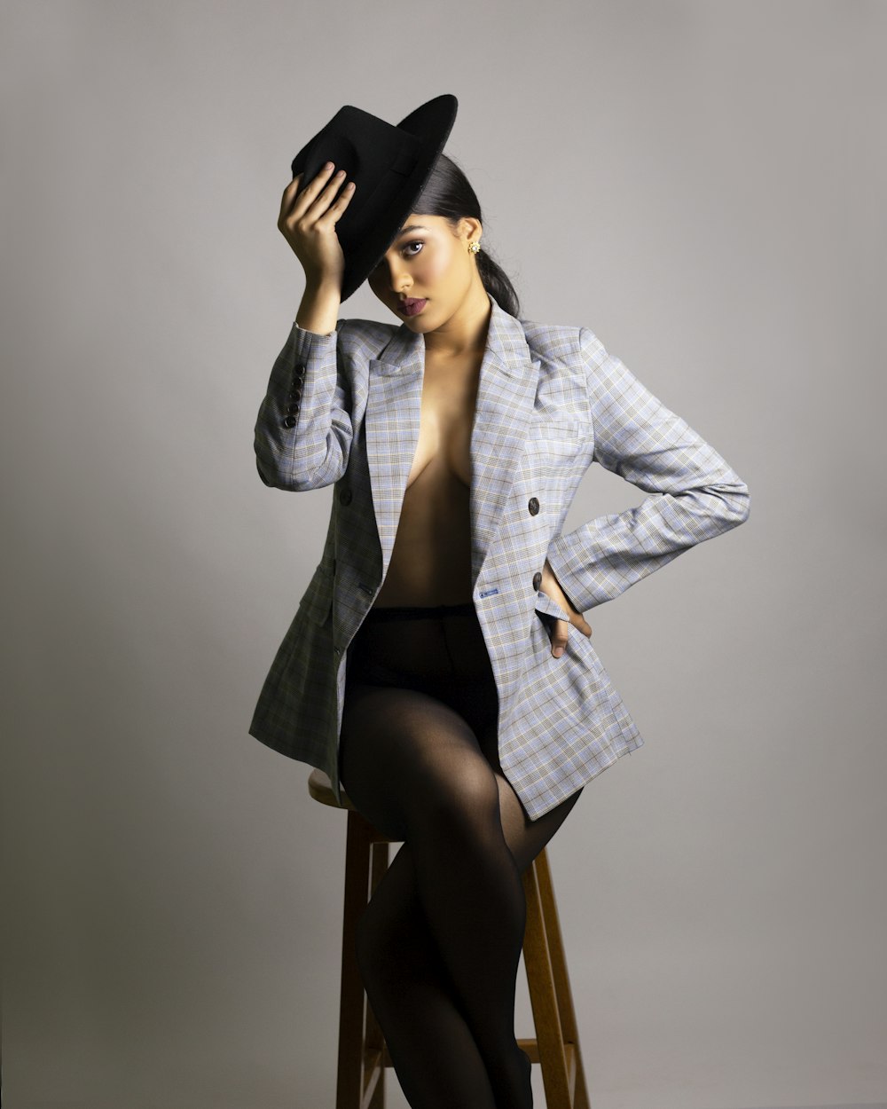 woman in gray blazer and black skirt sitting on brown wooden chair