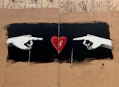 A close-up of hands holding a heart symbol.