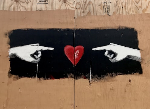 A close-up of hands holding a heart symbol.
