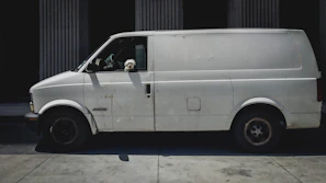 Wide shot of a van parked outside a vet clinic, ready for pet pick-up