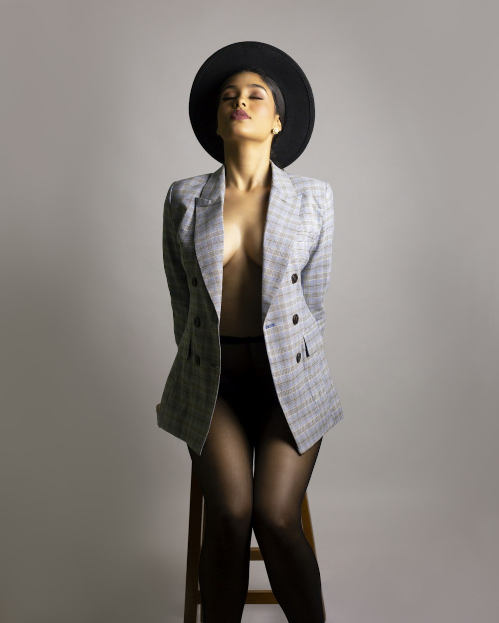 woman in black hat and gray blazer