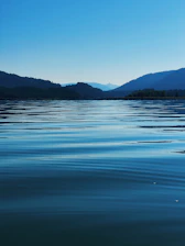 body of water near mountain during daytime