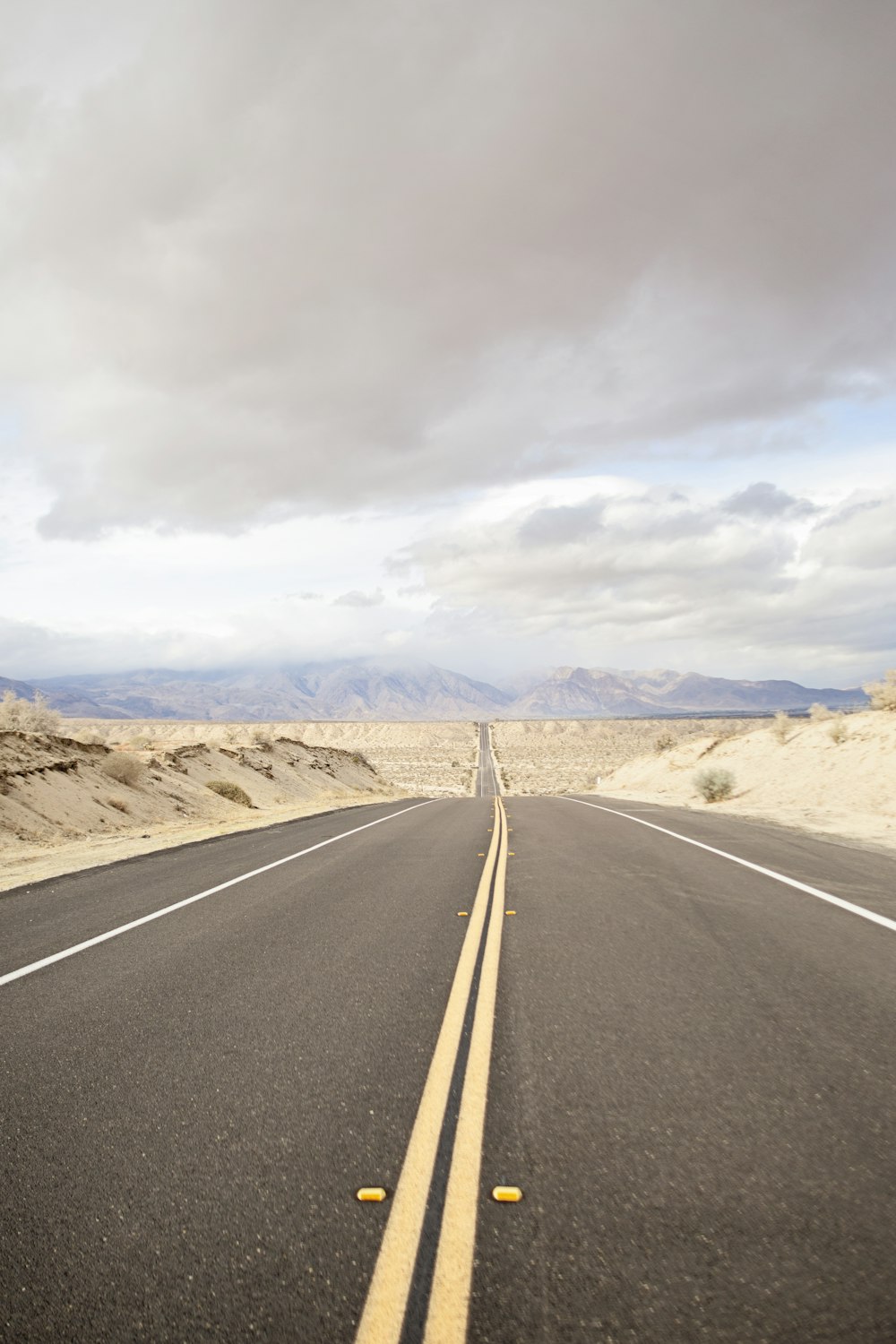 gray asphalt road under cloudy sky during daytime