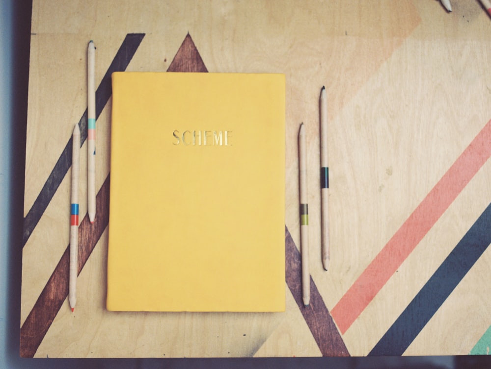 yellow and red book on brown wooden table