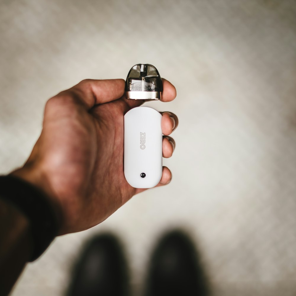 person holding white and silver bottle